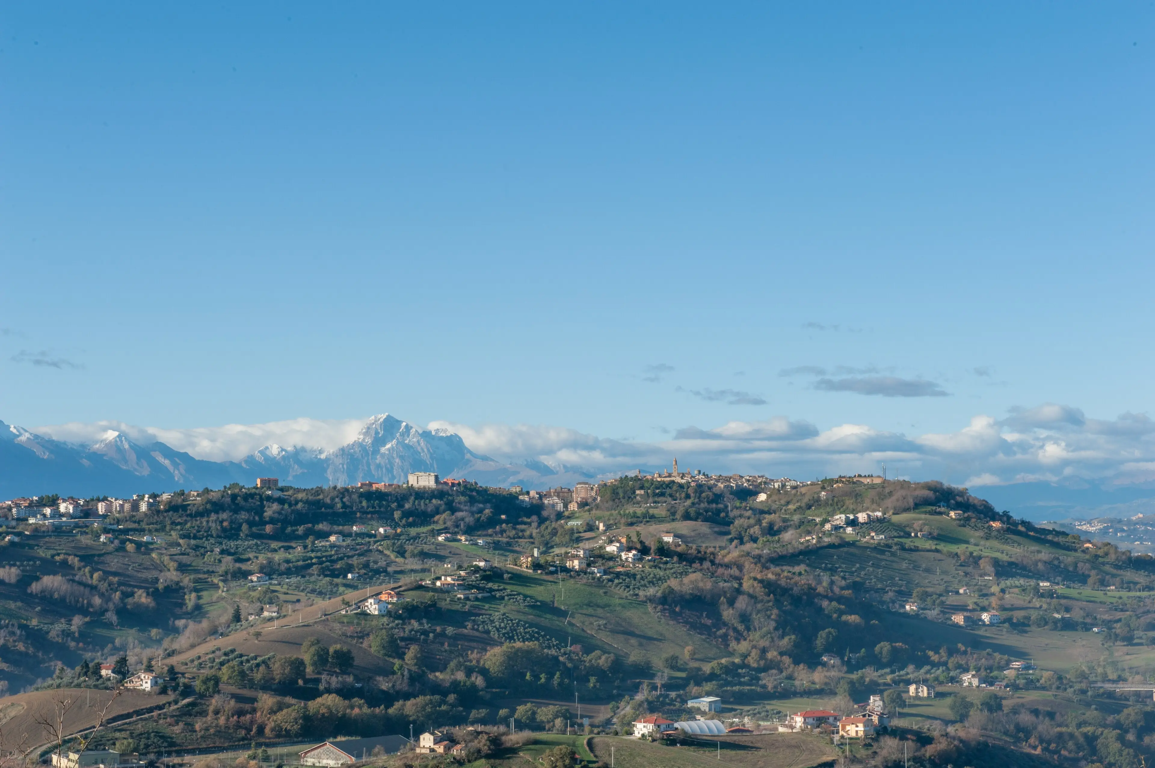 Atri sulla sua collina con il Corno Grande del Gran Sasso innevato alle spalle.
